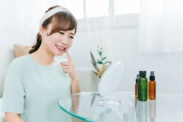 口内炎が痛くて、口元を気にしている女性