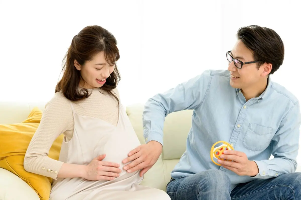 妊活を経て妊娠し、お腹が大きくなった奥さんを喜ぶ夫婦のイラスト