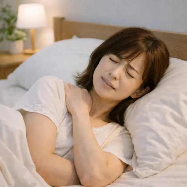 肩の夜間痛に苦しむ女性