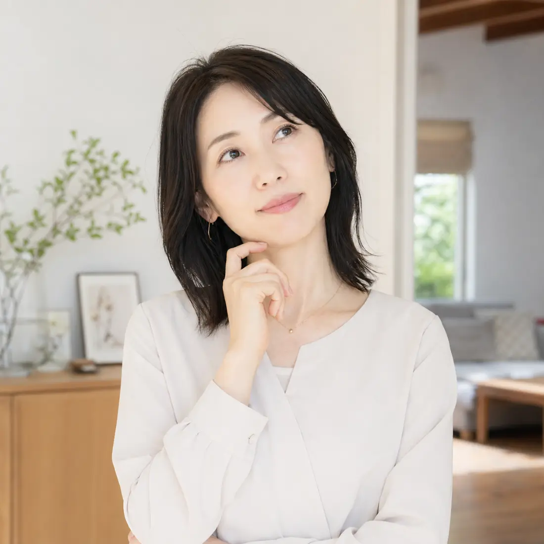 顎に手を当て首をかしげる女性