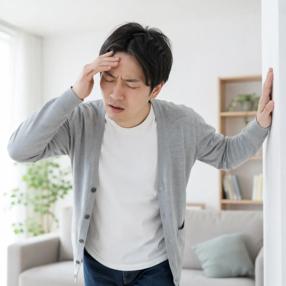 額に手を当てて立っている男性