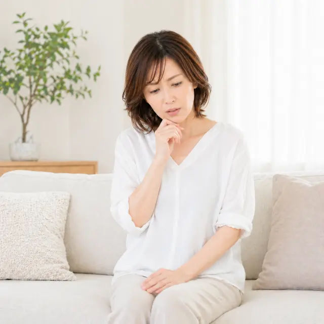 ソファーに座りうつむく女性