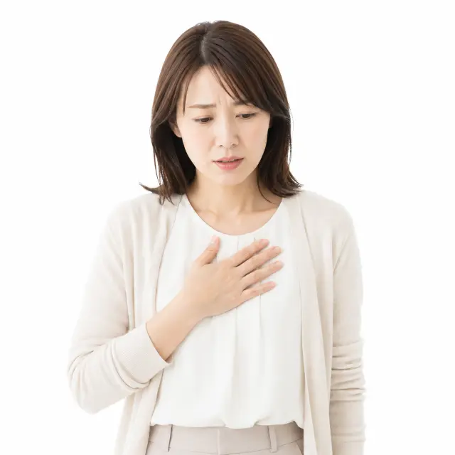 胸に手を当てうつむく女性