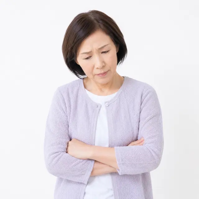腕を組みうつむく女性