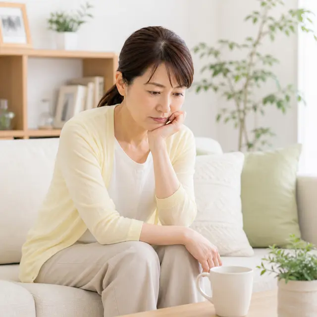 手で顎を支えソファーに座る女性