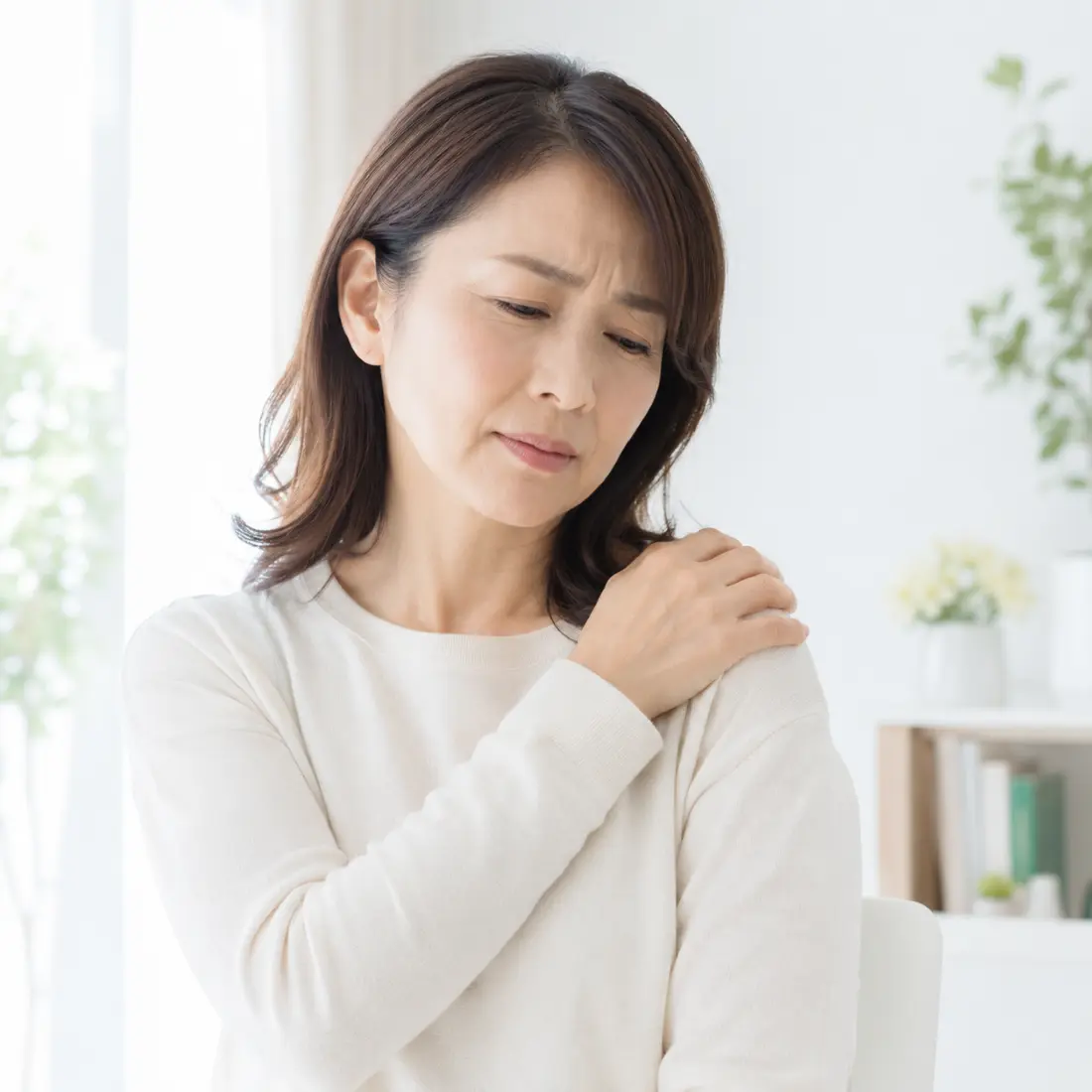 肩に手を当てる女性