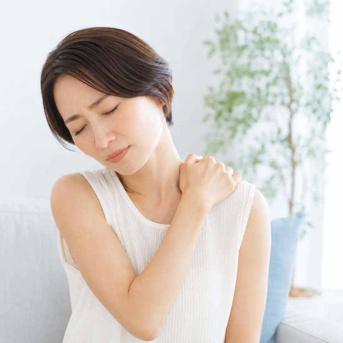 肩に手を当てる女性