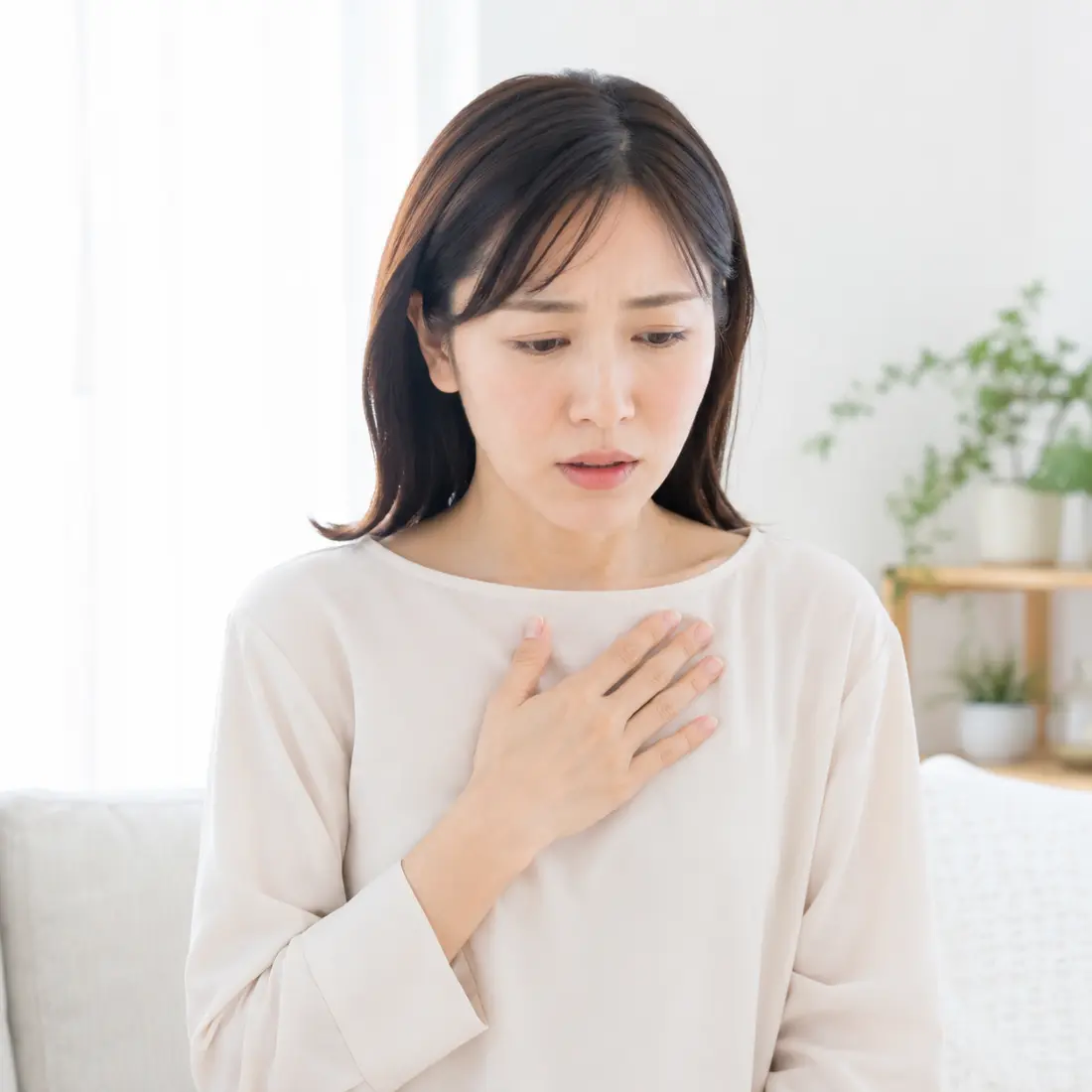 胸に手を当てる女性