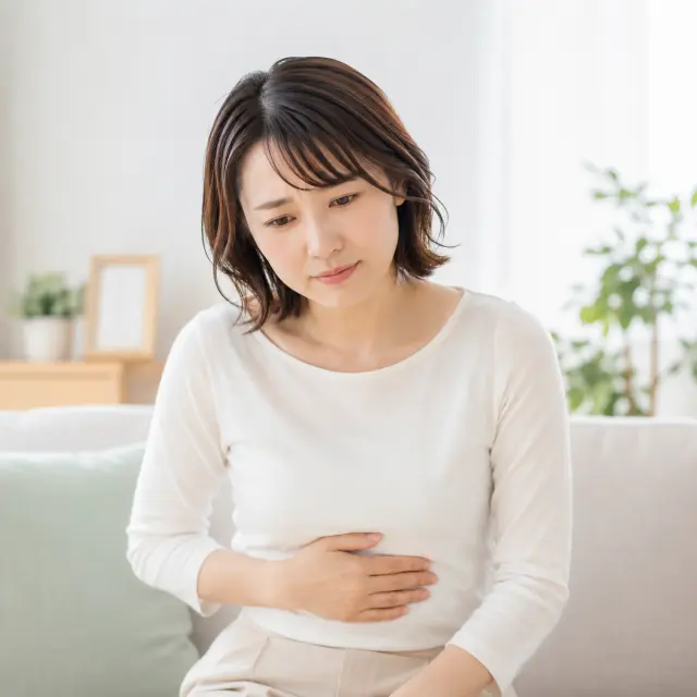 お腹に手を当てる女性