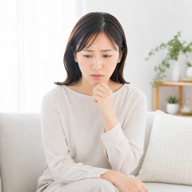 顎に手を当て下を見る女性