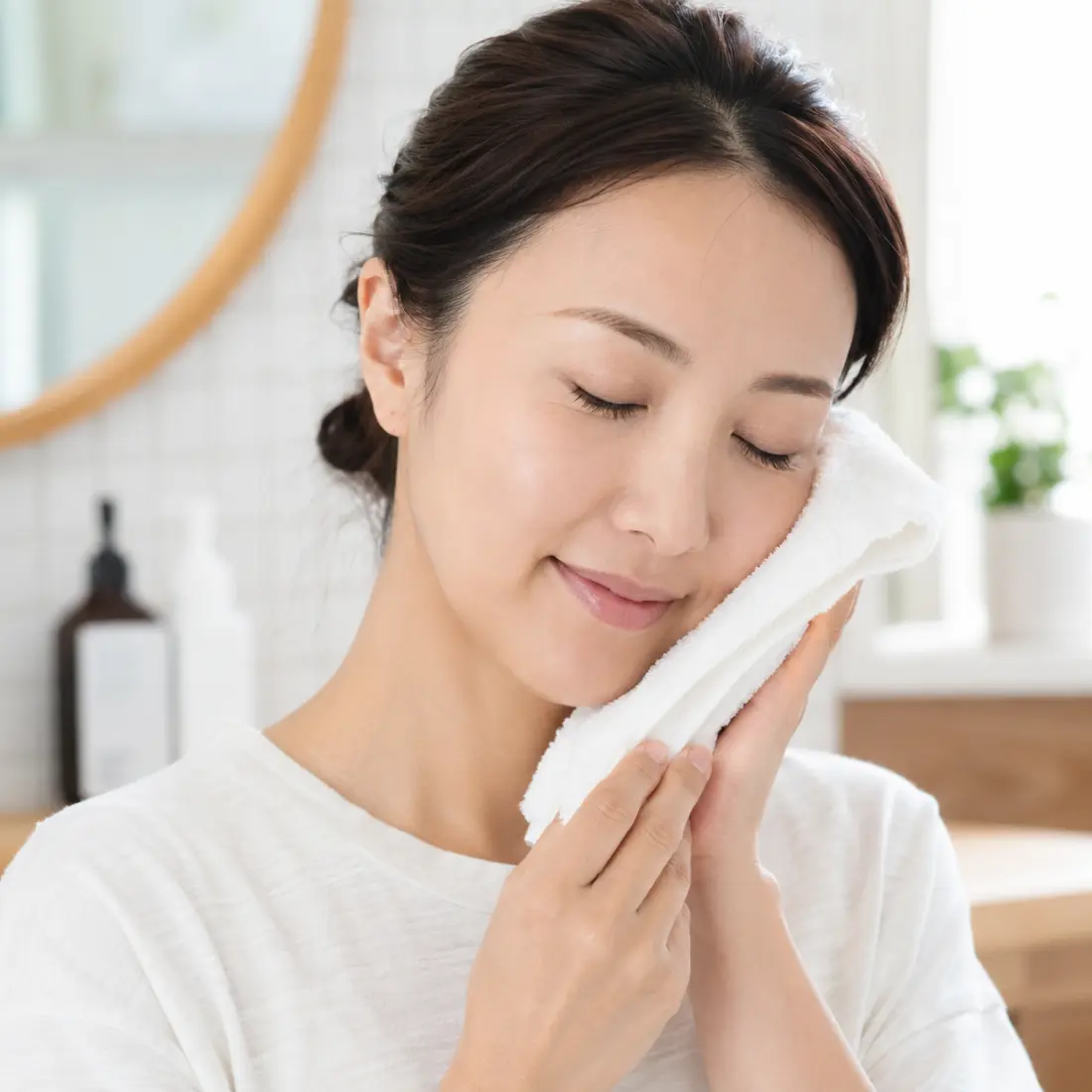 頬にタオルを当てる女性