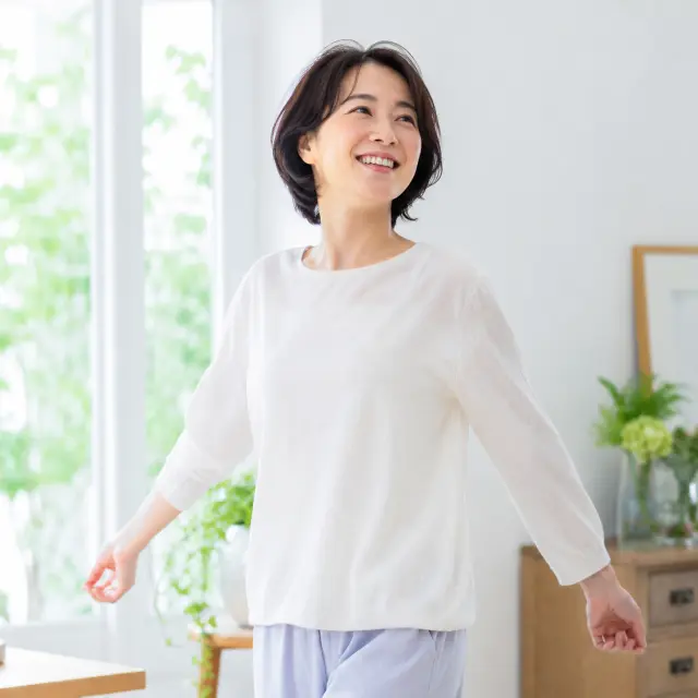 腕を広げて立つ女性