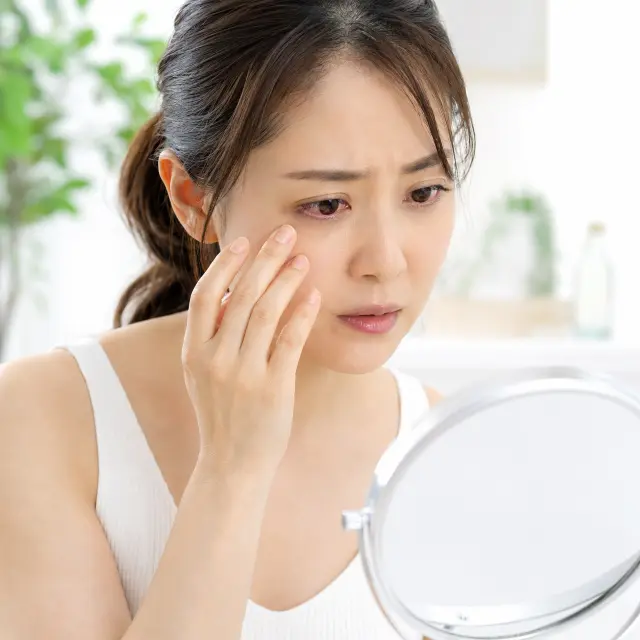目元に手を当てる女性