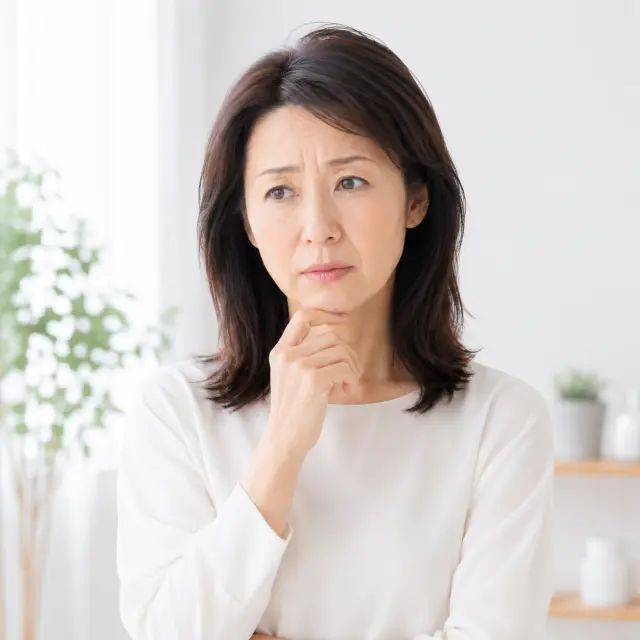 顎に手を当て遠くを見つめる女性