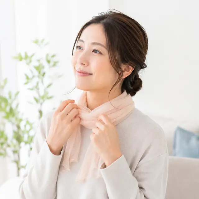 首にスカーフを巻く女性