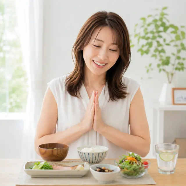 料理の前で手を合わせる女性