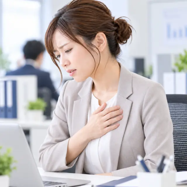 胸に手を当てる女性