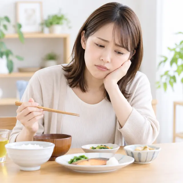 料理の前で頬に手を当てる女性