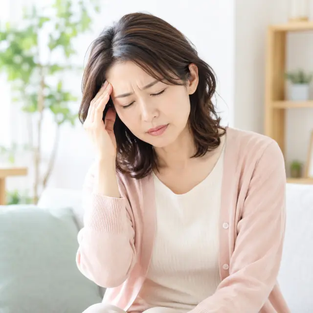 額に手を当てる女性